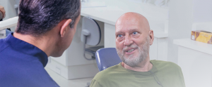 doutor falando com o paciente sobre o enxerto ósseo para implantes