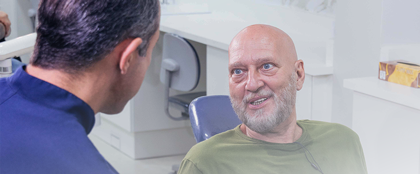 doutor falando com o paciente sobre o enxerto ósseo para implantes